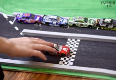 a person is playing with toy cars on a race track