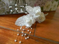 white flowers and pearls are on the floor next to a box with an eiffel tower in the background