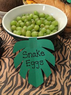 there is a bowl of green grapes next to a plate with an egg on it