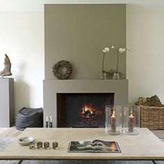 a living room filled with furniture and a fire place next to a wall mounted fireplace