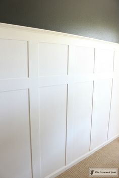 an empty room with white paneling on the wall and carpeted floor in front of it