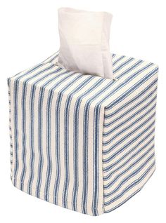 a blue and white striped tissue dispenser on a white background with a pillow