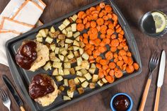 a tray with meat, potatoes and carrots on it