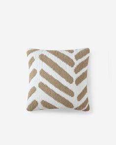 a brown and white pillow with an animal print pattern on the front, sitting against a white wall