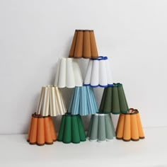 a group of different colored lamps sitting on top of a white table next to each other