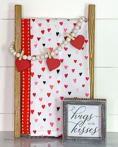 a wooden frame with hearts on it next to a sign and some other things in front of it