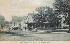 an old black and white photo of a street with houses in the middle of it