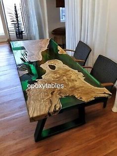 the table is made out of wood and has green leaves on it, along with two chairs