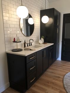 a bathroom with black cabinets and white tiles