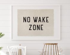 a white chair sitting in front of a framed sign that says no wake zone on it