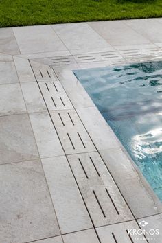 an empty swimming pool surrounded by green grass