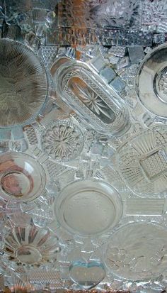 an assortment of glass plates and bowls on display