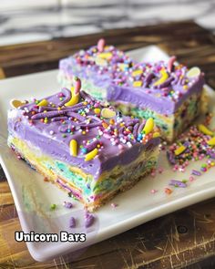 two slices of unicorn bars on a plate with sprinkles