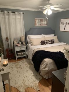 a bed room with a neatly made bed next to a night stand and a window