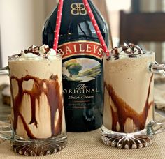 two glasses filled with ice cream next to a bottle of bailey's chocolate milkshake