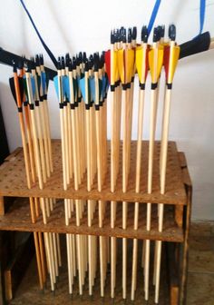 several wooden sticks are lined up on a shelf with blue and yellow poles attached to them