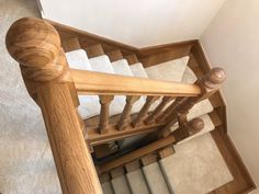 a wooden staircase with white carpet and handrail