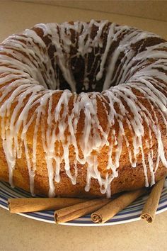 a bundt cake sitting on top of a blue and white plate next to cinnamon sticks