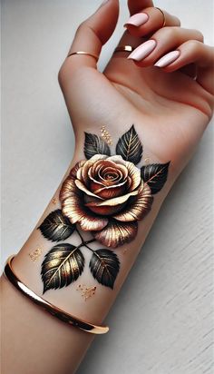 a woman's arm with a rose tattoo on it and gold foil around the wrist