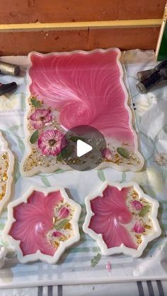 pink and white plates with flowers on them sitting on a table next to other items