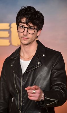 a man wearing glasses and a leather jacket