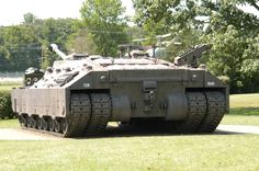 an army tank is parked in the grass