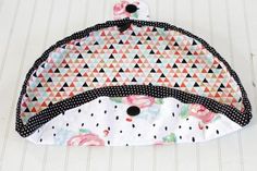 two pieces of fabric with black dots and pink flowers on them sitting on a white surface