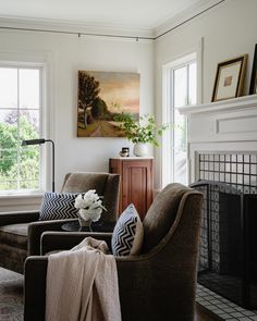 a living room filled with furniture and a fire place in front of a painting on the wall