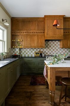 a kitchen with green cabinets and white counter tops