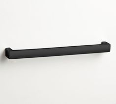 a black shelf mounted to the side of a white wall with a handle on it