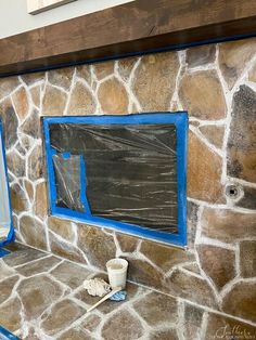 a stone wall with blue trim around it and a window in the middle that has been painted