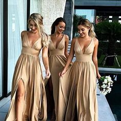 three beautiful women in long dresses standing next to each other