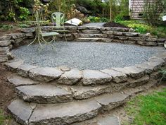 a stone patio surrounded by grass and rocks