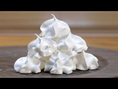 a pile of whipped cream sitting on top of a wooden table covered in white frosting