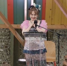 a woman standing at a podium with a microphone