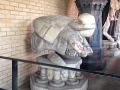 there is a statue that looks like an elephant in the middle of a room with brick walls