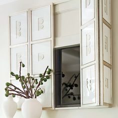 a vase with some flowers in it sitting on a shelf next to a mirror and window