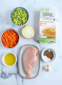 ingredients to make chicken broth laid out on a marble counter top