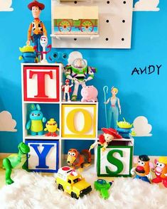 toys are arranged in the shape of letters and characters on display against a blue wall