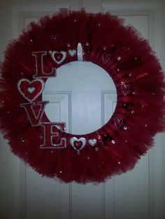 a red tulle wreath with i love you written on the front and side in silver glitters