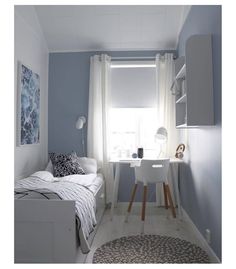 a bedroom with blue walls and white furniture