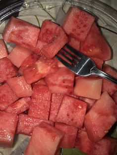 watermelon cubes in a glass bowl with a fork