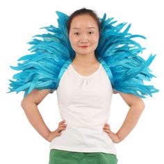 a woman with blue feathers on her head and arms behind her back, posing for the camera