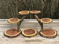 four pieces of wood stacked on top of each other in front of some bushes and trees