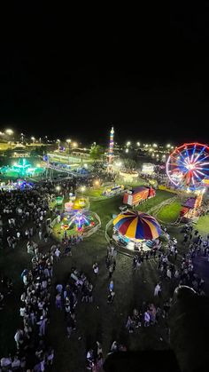 an aerial view of the fairground at night, with many rides and carnival booths