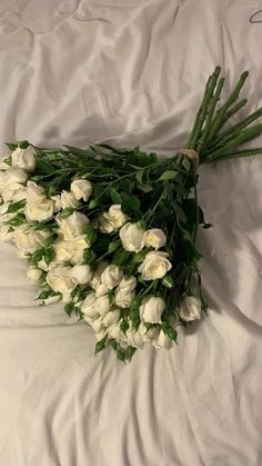 a bunch of white flowers laying on top of a bed