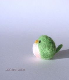 a small green bird sitting on top of a white table