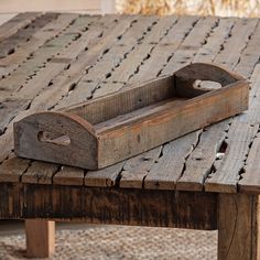 an old wooden tray sitting on top of a table with nails sticking out of it