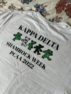 a white t - shirt with the words kapa delta and shamrocks on it