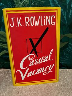 a red and yellow sign with the words j k rowling on it's side